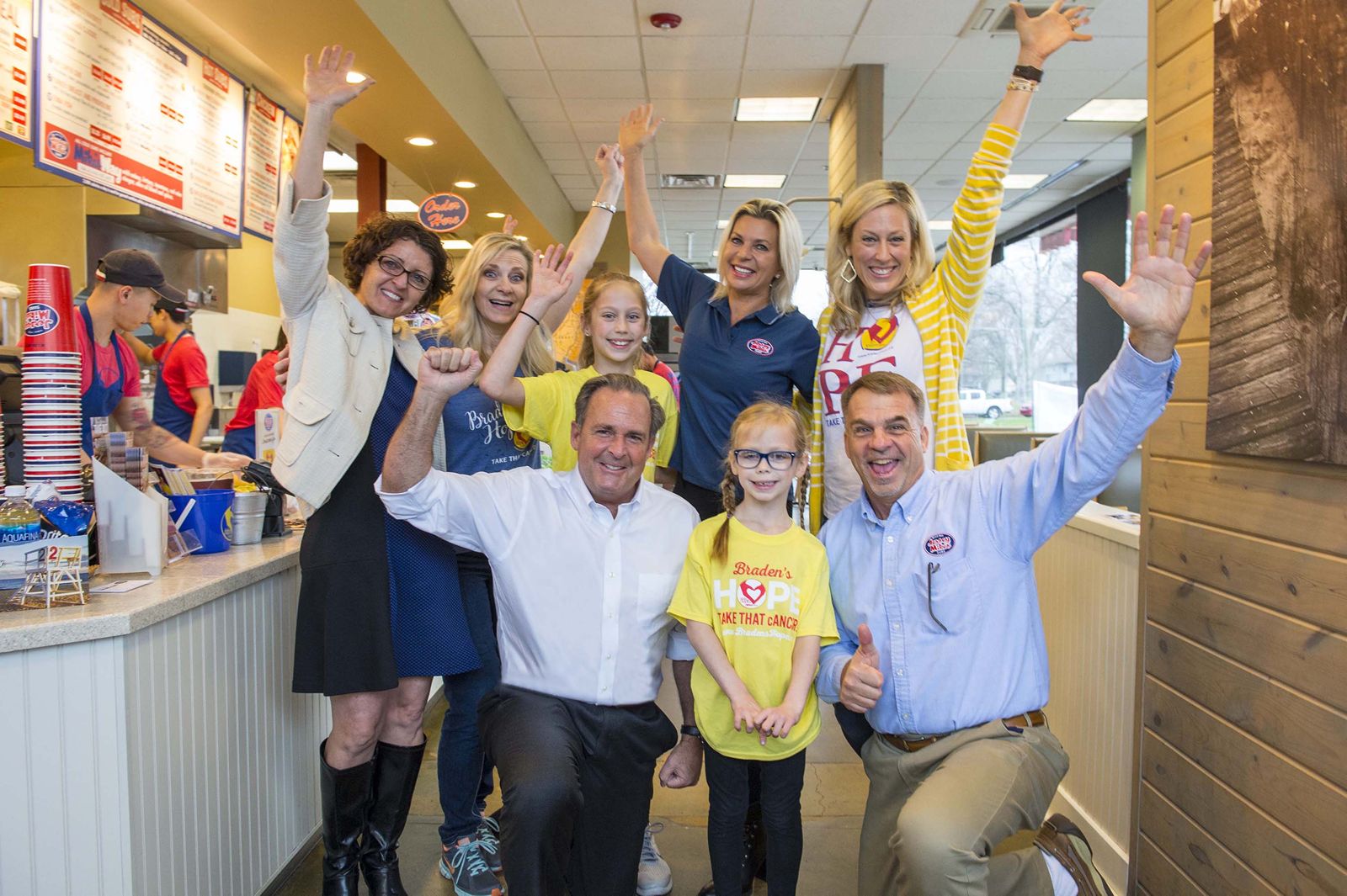 Jersey Mike’s Founder & CEO Peter Cancro (kneeling, left) celebrated the company’s 8th Annual Day of Giving with Callyn Stanley (front center) and Area Director Mike Spiegel at the Olathe, Kansas, restaurant. They were joined by (back row, from left) Shelia Montgomery, Deliece Hofen, founder of local charity partner Braden’s Hope, Taylor Stanley, Tatiana Voevodina Cancro, and Kim Stanley.