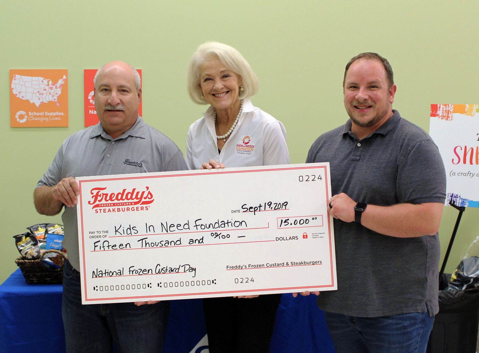 Scott Redler, COO & Co-Founder, Freddy's Frozen Custard & Steakburgers presenting the donation check to Kristine Cohn, Senior Director of Development & Corporate Partnerships, Kids In Need Foundation and Terry Johnson, Director & Founder of Project Teacher.